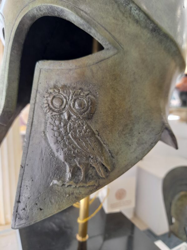 Life Size Bronze helmet with owl of Athena on cheek plate on black marble bas